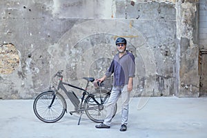 man standing in front of electric bicycle