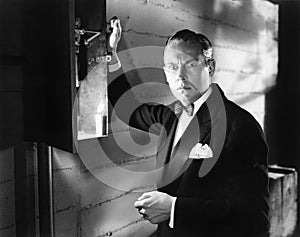 Man standing in front of a fuse box looking frightened