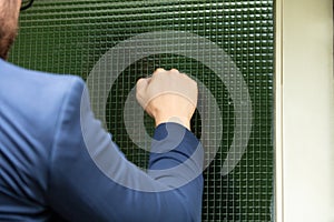 Man Standing In Front Of The House Knocking The Door