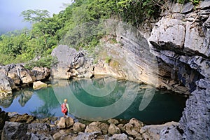 Man standing front of a jade green lake, a peaceful and romantic scenery