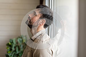 Man Standing in Front of Window, Feeling Down