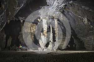 Man standing beside a group of stalactite cave 3