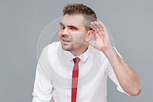 man standing with hand near ears and trying to listening