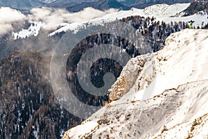 Uomo in piedi sul alto scogliera più alto nuvole 