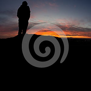 Man standing on hill in black forest at sunset