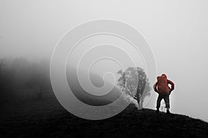 Man standing on hill with fog