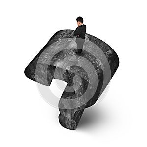 Man standing on huge 3D concrete question mark white background