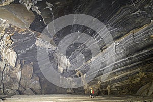 Man standing into a huge cave