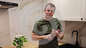 Man Standing in Kitchen Next to Sink