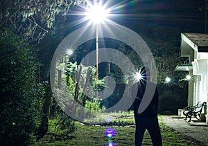 Man standing on a lawn looking at the stars in the night sky during a cold winter night. long exposure shot of a man.