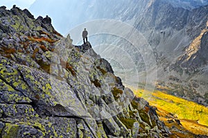 Man standing on a ledge of a mountain, enjoying the beautiful sunset over a wide river valley in Slovakia