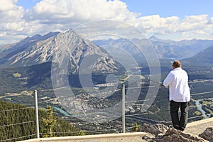 Man looking at a panorama of a small town Banff in a Bow river valley