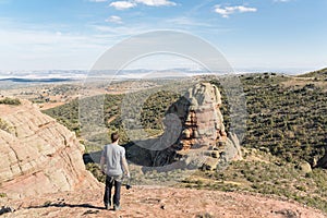 Man standing and looking at a Rodeno Boulder in Perecense, Teruel, Spain photo