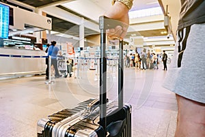 Man standing with luggage at airport. man looking at lounge looking at airplanes while waiting at boarding gate