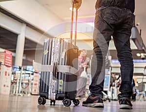 Man standing with luggage at airport. man looking at lounge looking at airplanes while waiting at boarding gate before departure