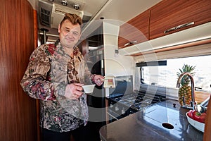 Man standing in motor home holding coffee in cezve and cup