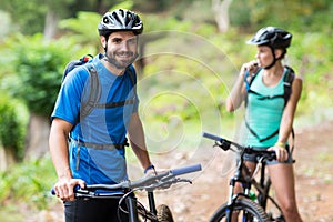 Man standing with mountain bike in forest