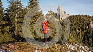 Man standing on mountain ridge in front of beautiful rock formation