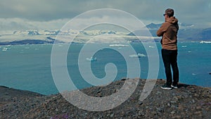 Man standing on mountain`s peak. Glacier lagoone.