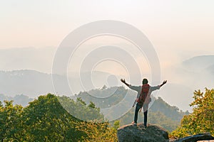 man is standing on a mountain top, looking out over the landscape