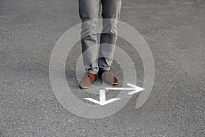 Man standing near arrows on asphal