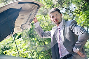 Man standing near breakdown car