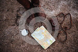 Man standing near map, hip flask and photo camera case