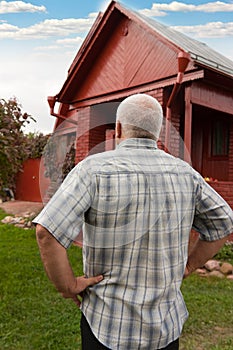 Man standing near red house