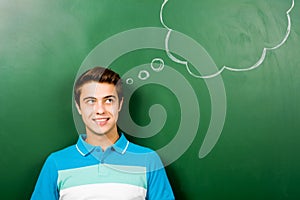 Man standing next to thought bubble on blackboard