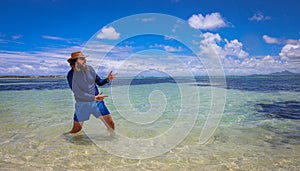 Man Standing in Ocean With Hat On
