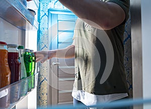 Man standing in the open door of a refrigerator