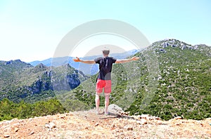 Man standing with open hands in front of the mountains at Lakonia Peloponnese Greece