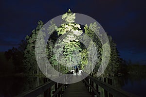 Man standing outdoor at dark night shining with flashlight