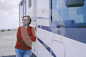 Man standing outside camper van in travel holiday vacation. Renting rv vehicle and enjoy freedom. Mature people with motor home.