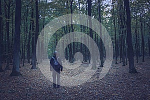 A man standing on a path in a dark forest