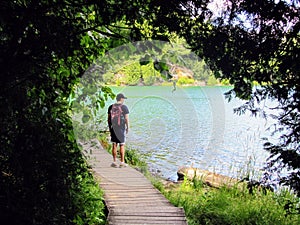 Man standing on a pathway by a remote lake thinking and contemplating