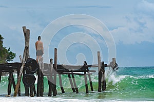 Man standing at the pier and watching the ocean