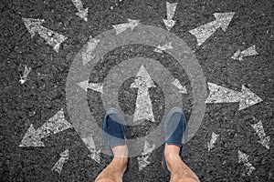 Man standing on road with many direction arrow choices or move