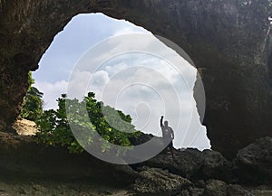 A man is standing in a rock cave