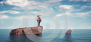 Man standing on a rock in the middle of ocean surrounded by sharks