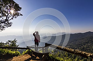 Man standing on rock at sunset with mountains below