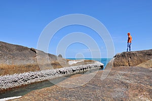 Man standing on the rocks, sea and blue sky in samui island Tha