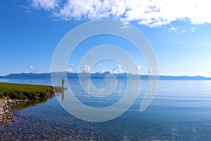 Man standing beside Sayram Lake.