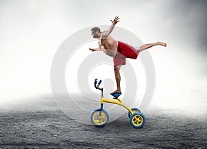 Man standing on a small bicycle