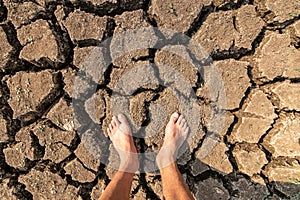 Man standing on soil dry land cracked ground surface. Landscape dried and cracked background