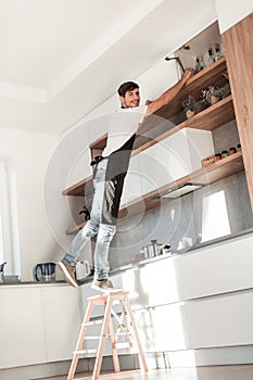 man standing on a stepladder in the home kitchen