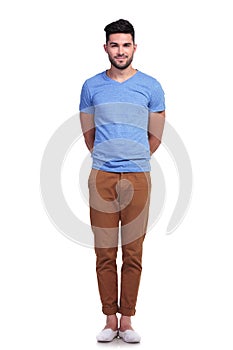 Man standing straight with hands at his back