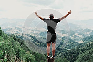 Man standing on of stump in summer mountains