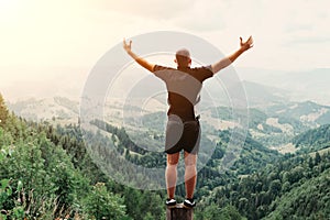 Man standing on of stump in summer mountains