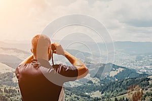 Man standing on of stump in summer mountains